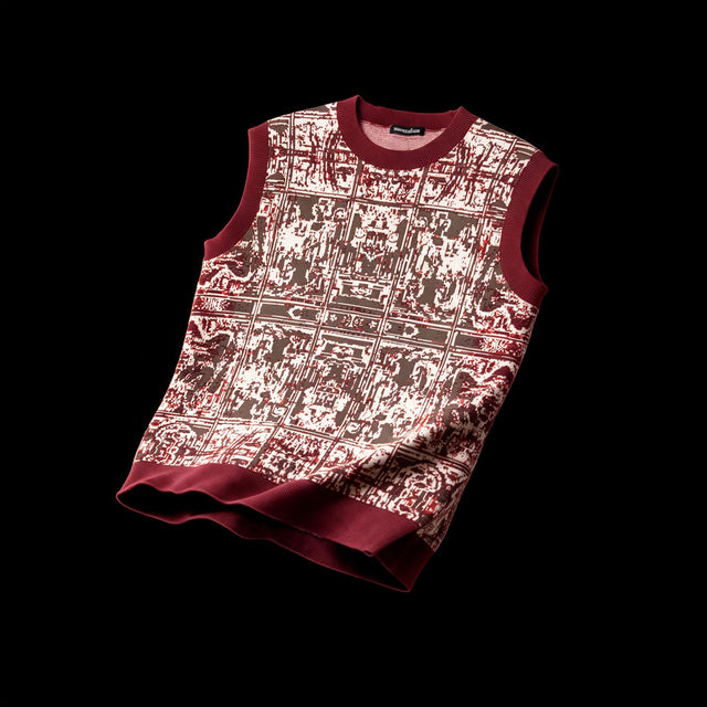 Sleeveless jacquard knit vest with a worn tapestry pattern in deep red, brown and cream, ribbed red trim