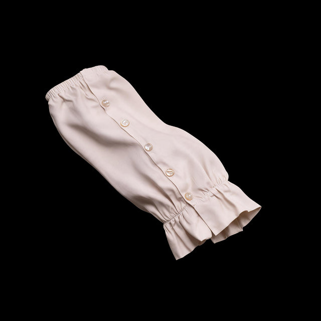 Pair of ivory detachable sleeve cuffs with a button placket and ruffled wrist, one shown flat