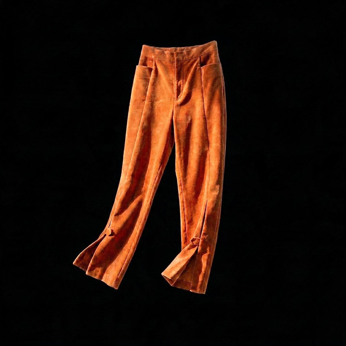 High waisted burnt orange velvet trousers with slim tapered legs and split buttoned ankles on black