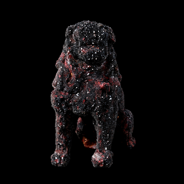 Seated guardian lion sculpture crusted in sparkling black obsidian over dark red, front view