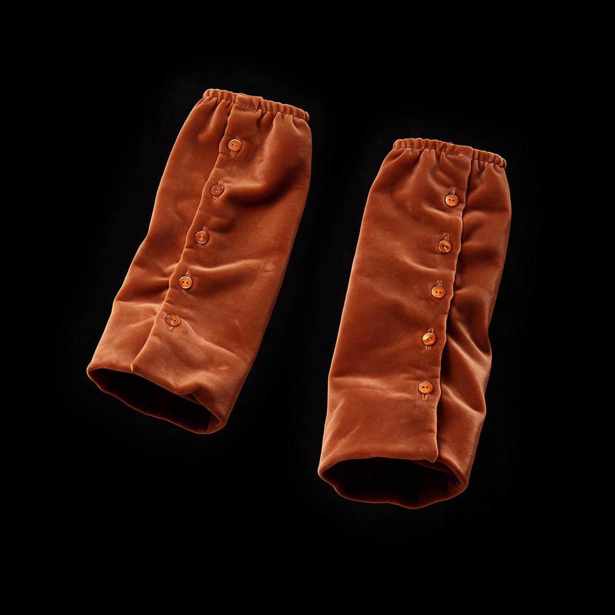 Pair of rust velvet forearm cuffs with buttoned plackets and gathered ends