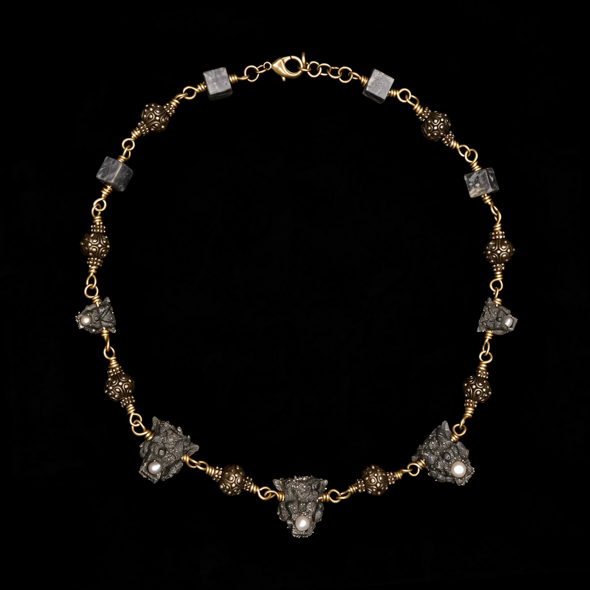 Otherworldly gothic necklace of pyrite crusted gargoyle heads with pearls, brass filigree beads and stone cubes on a brass ch