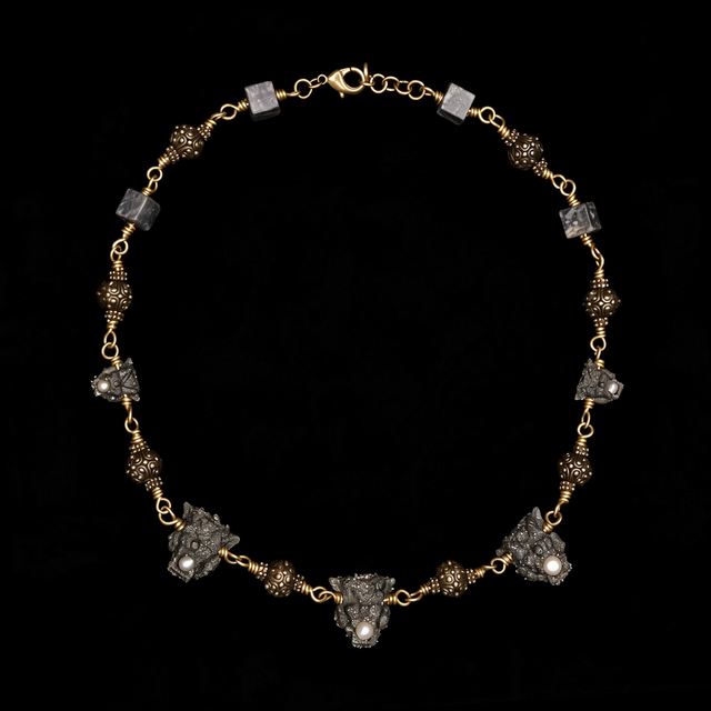 Otherworldly gothic necklace of pyrite crusted gargoyle heads with pearls, brass filigree beads and stone cubes on a brass ch